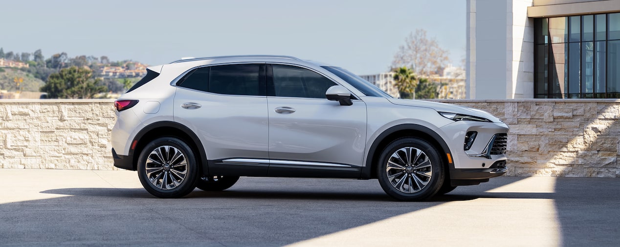 Side View of a 2024 Buick Envision Small SUV Parked Near a Stone Wall