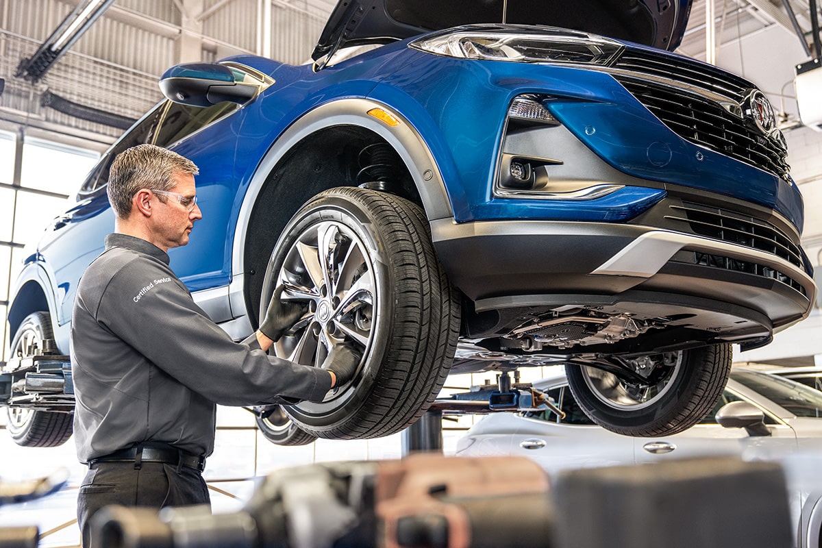 Buick Certified Service Representative Inspecting a Vehicle's Tire