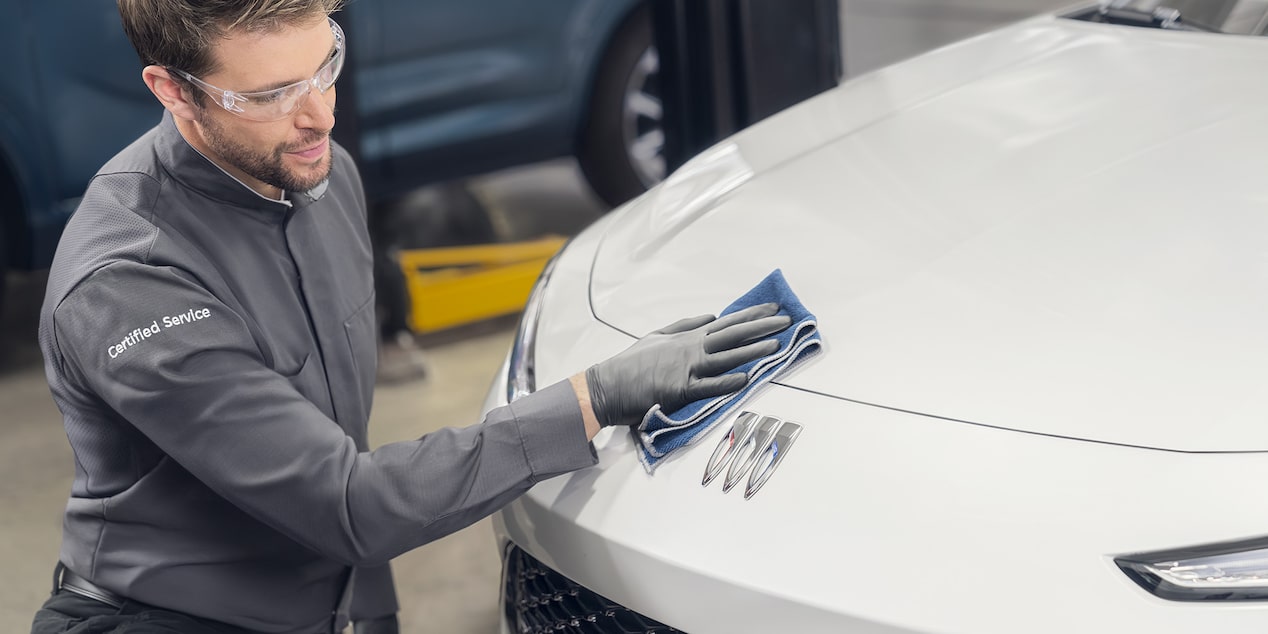 Buick Certified Service Technician Cleaning the Grille on a Buick Vehicle