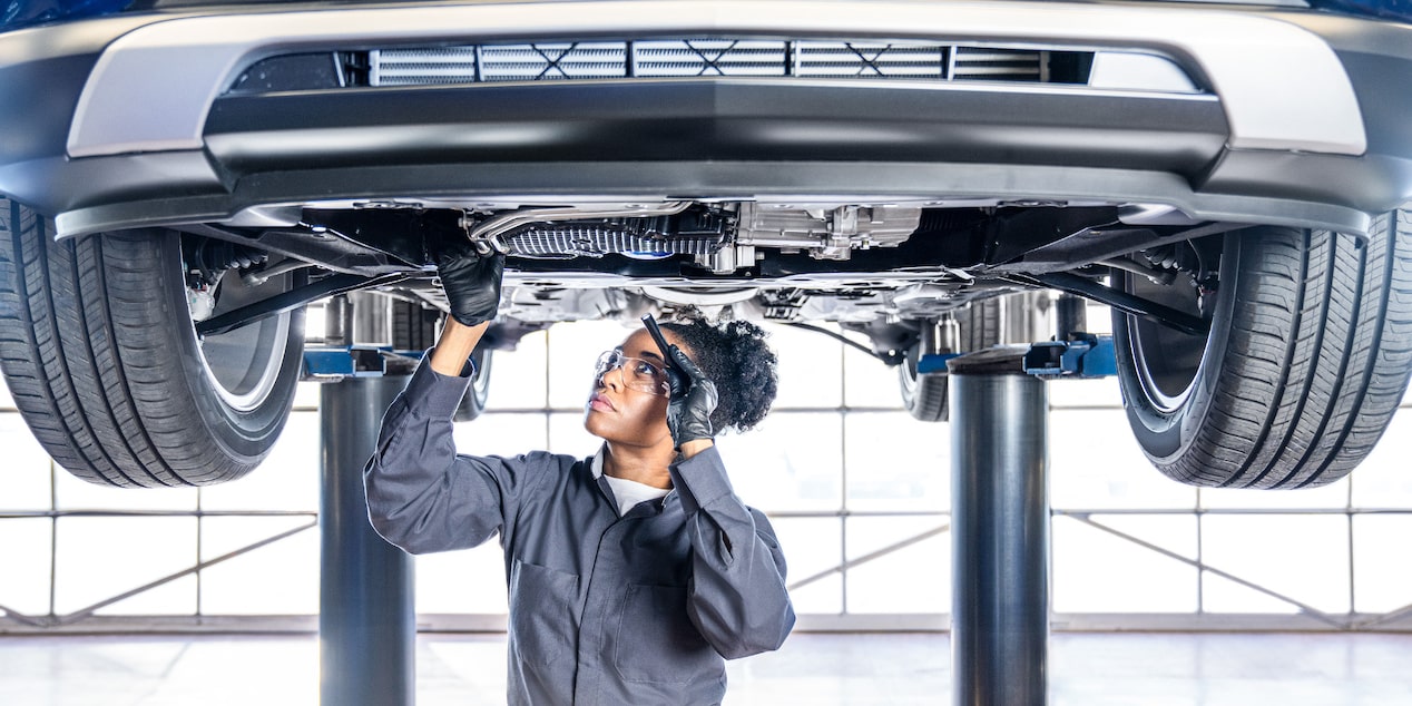 Close-up of a Buick Certified Service Technician Inspecting Underside of a Vehicle