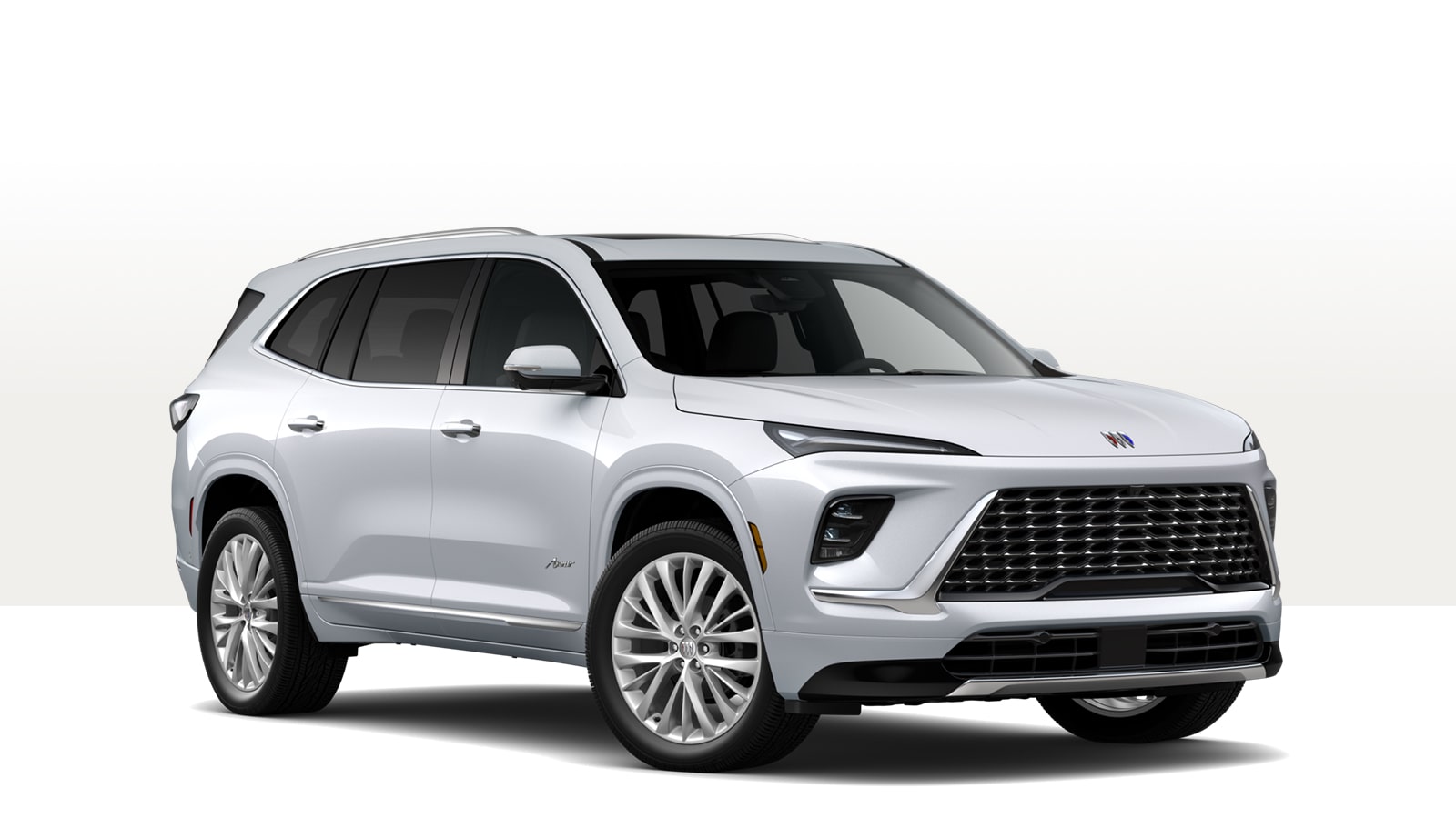 A White Buick Enclave Avenir Luxury Mid-Size SUV From the Front Three-Quarter View With a Chrome Grille and Spoke Wheels
