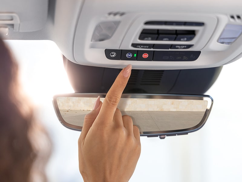 Close-up of a Woman Pressing the OnStar Button in her Vehicle