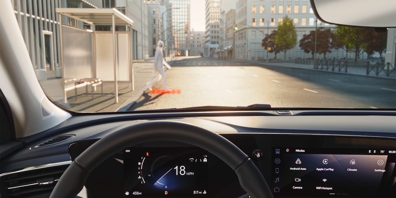 Steering Wheel View of Buick Utilizing Front Pedestrian Braking Feature While Pedestrian Walks in Front of Vehicle