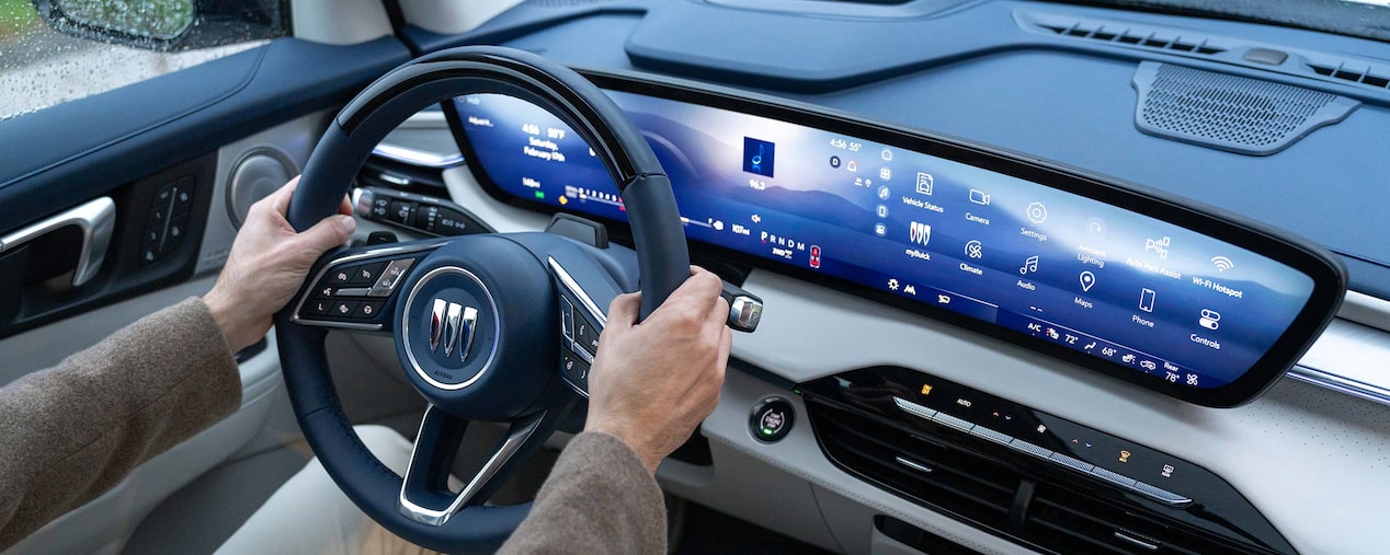 A Man Holding the Buick Steering Wheel as the 30 Inch Infotainment Screen is Lit Up